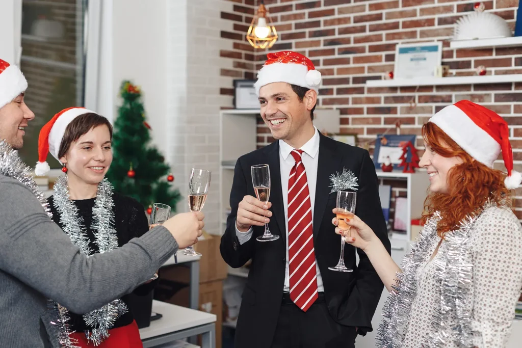 Weihnachtsfeier planen: So wird Ihre Betriebsweihnachtsfeier ein Erfolg 1 Kollegen stoßen auf der Weihnachtsfeier an